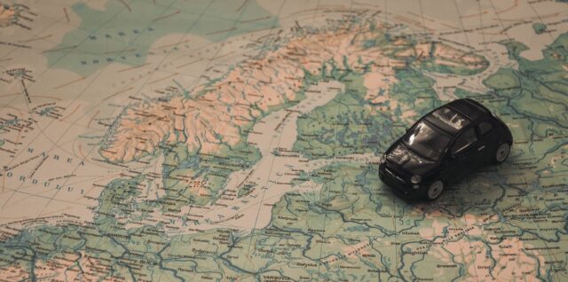 black toy car on world map paper